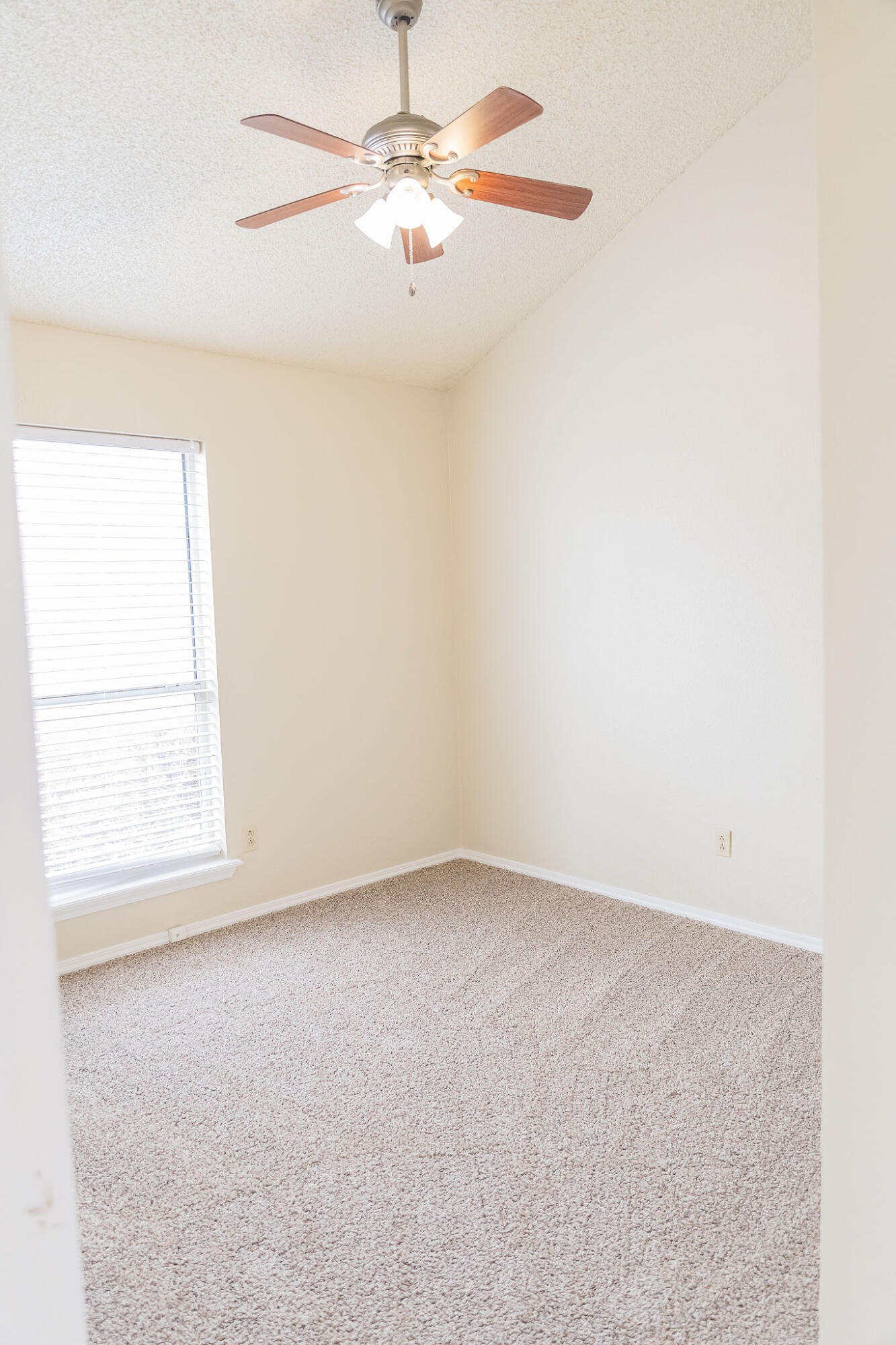 2120 93rd Street Lubbock, TX 79423 - Photo 18 of 32 an empty room with a window and a fan