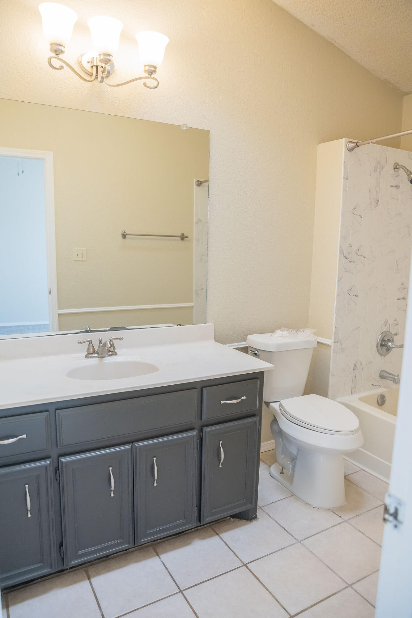 2120 93rd Street Lubbock, TX 79423 - Photo 24 of 32 a bathroom with a granite countertop toilet sink and mirror