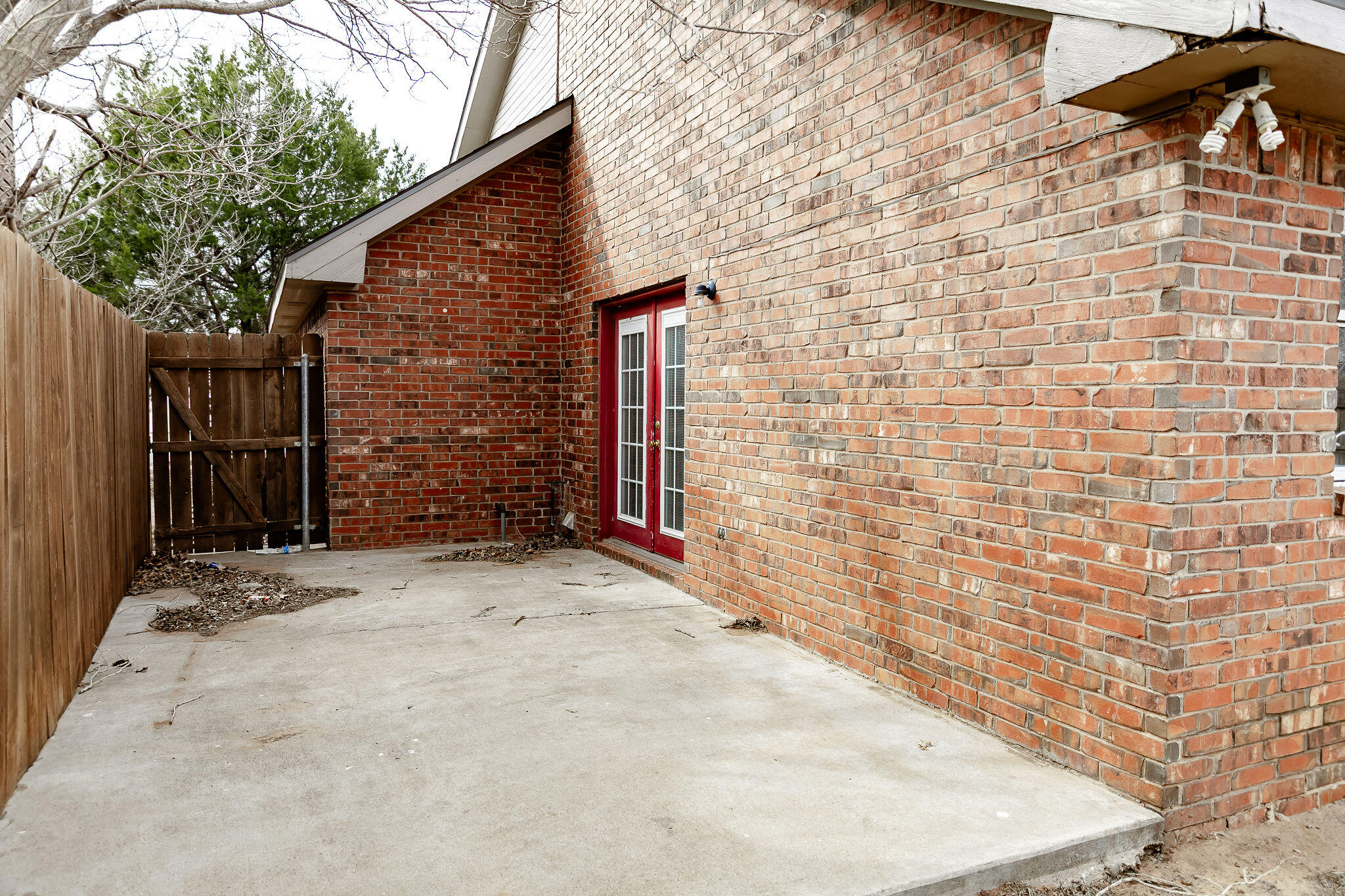 2120 93rd Street Lubbock, TX 79423 - Photo 28 of 32 a view of a brick house with brick wall and wooden fence