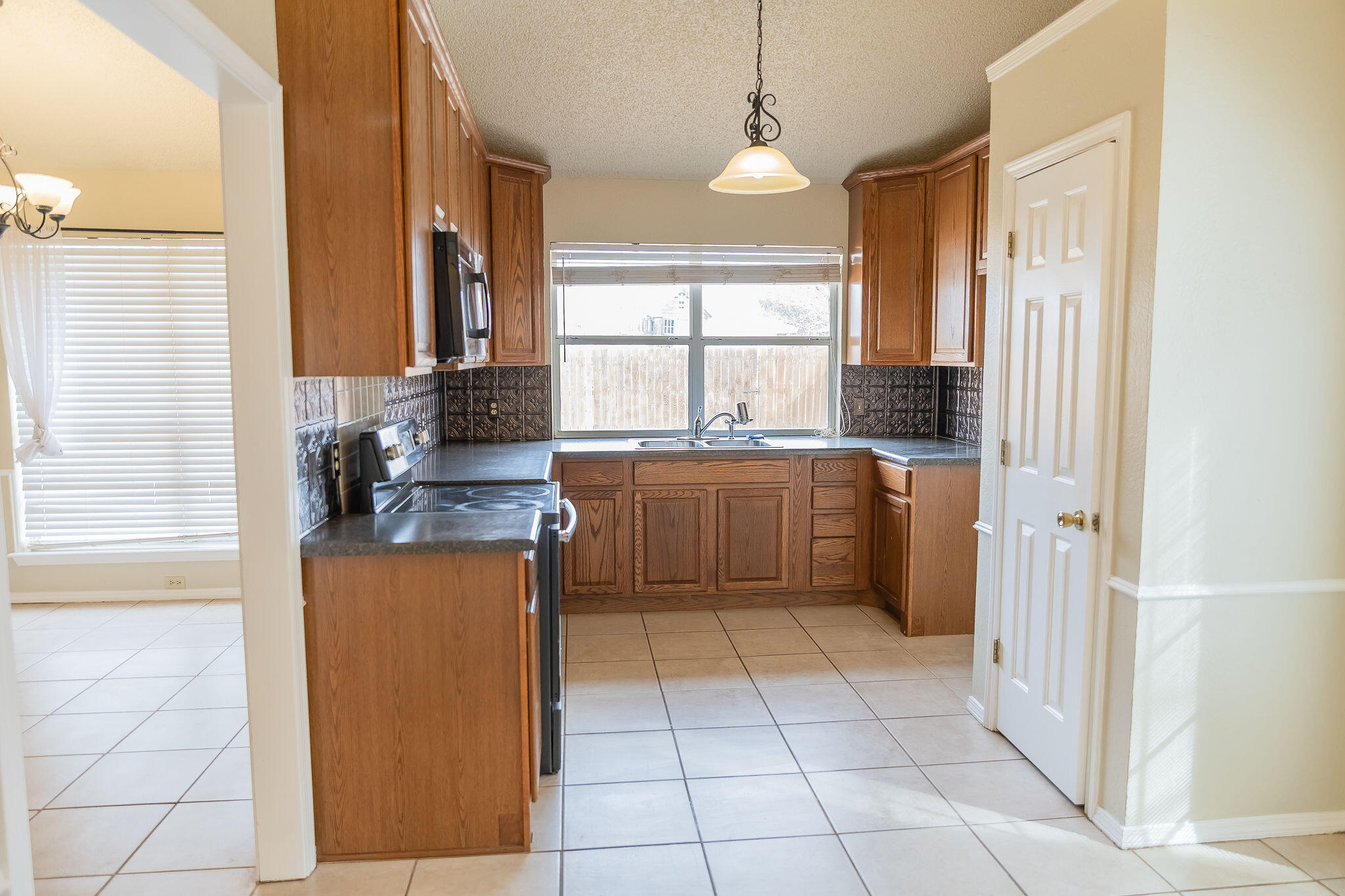 2120 93rd Street Lubbock, TX 79423 - Photo 32 of 32 a kitchen with stainless steel appliances granite countertop a sink and a refrigerator