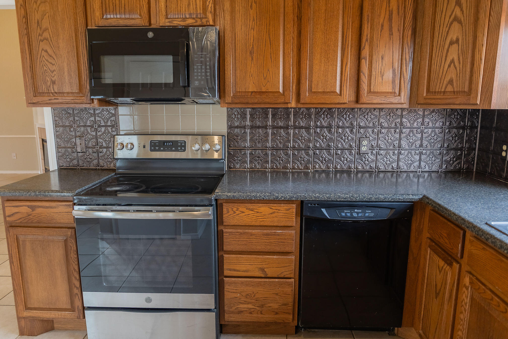 2120 93rd Street Lubbock, TX 79423 - Photo 10 of 32 a kitchen with a stove and a microwave