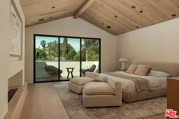 a bedroom with furniture and large windows