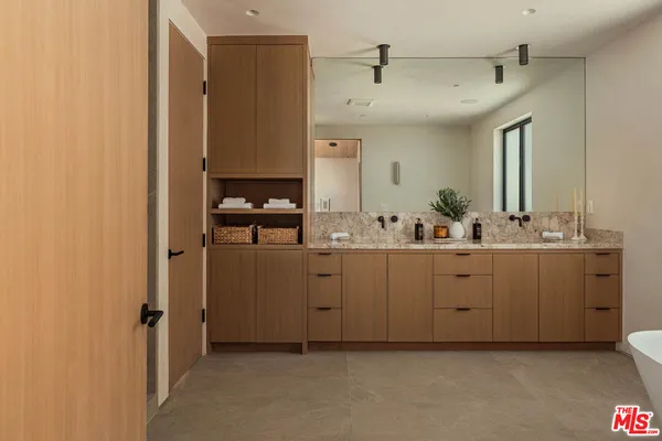 a spacious bathroom with a double vanity sink a mirror and shower