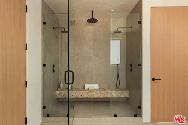 a bathroom with a granite countertop shower a mirror and a sink