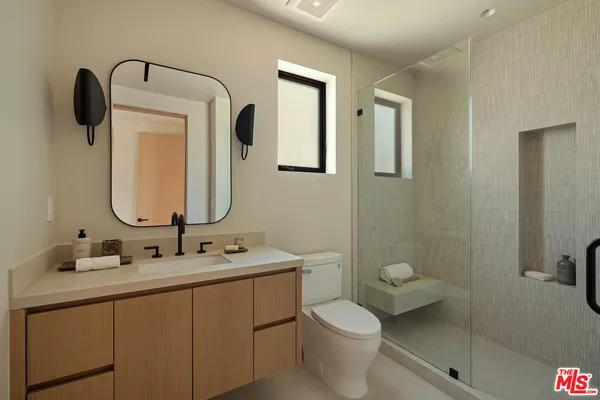 a bathroom with a toilet sink and mirror