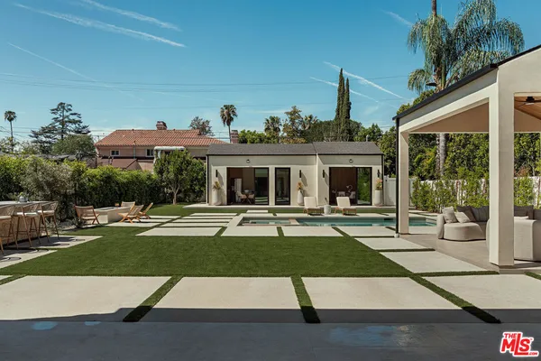 a view of a house with backyard sitting area and garden