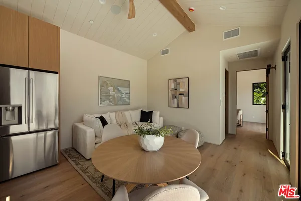 a dining room with furniture a wooden table and kitchen