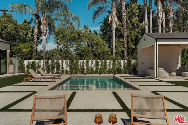 a view of backyard with swimming pool and seating area