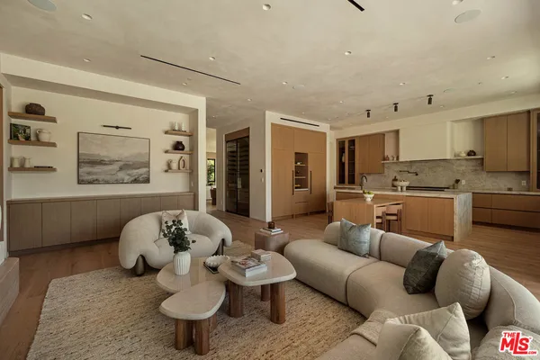 a living room with furniture and kitchen view