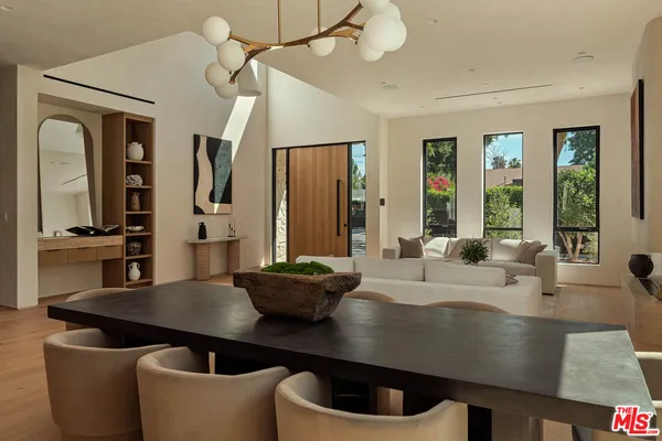 a living room with stainless steel appliances a dining table and chairs