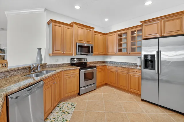 a kitchen with stainless steel appliances a sink a stove a microwave a counter top space and cabinets