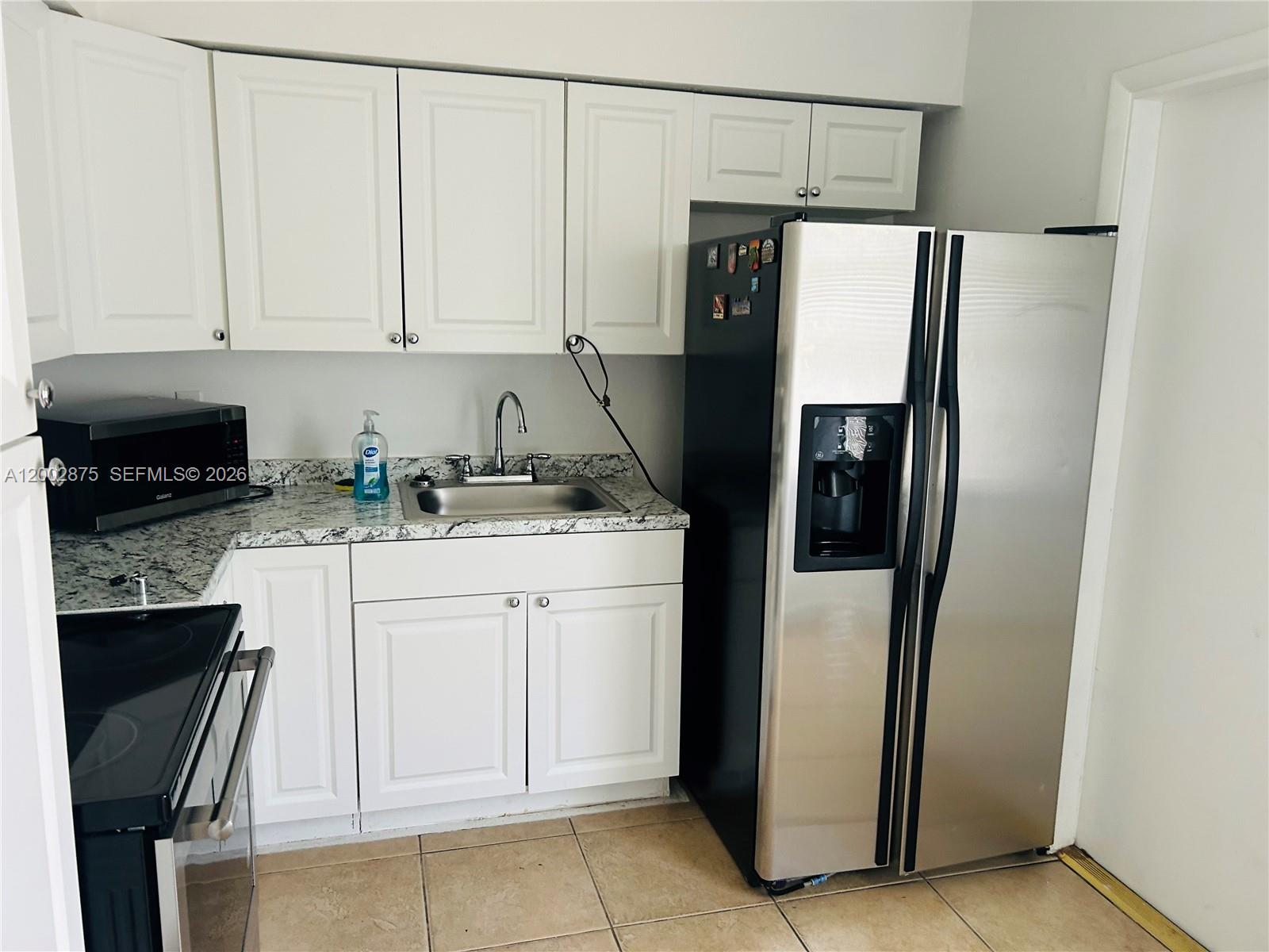 412 Southwest 10th Street, Unit 12 Hallandale Beach, FL 33009 - Photo 4 of 11 a kitchen with stainless steel appliances a refrigerator sink and cabinets
