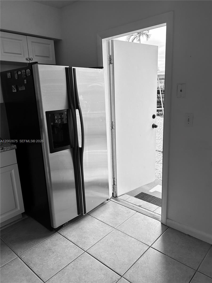 412 Southwest 10th Street, Unit 12 Hallandale Beach, FL 33009 - Photo 6 of 11 a view of a refrigerator in kitchen and an empty room