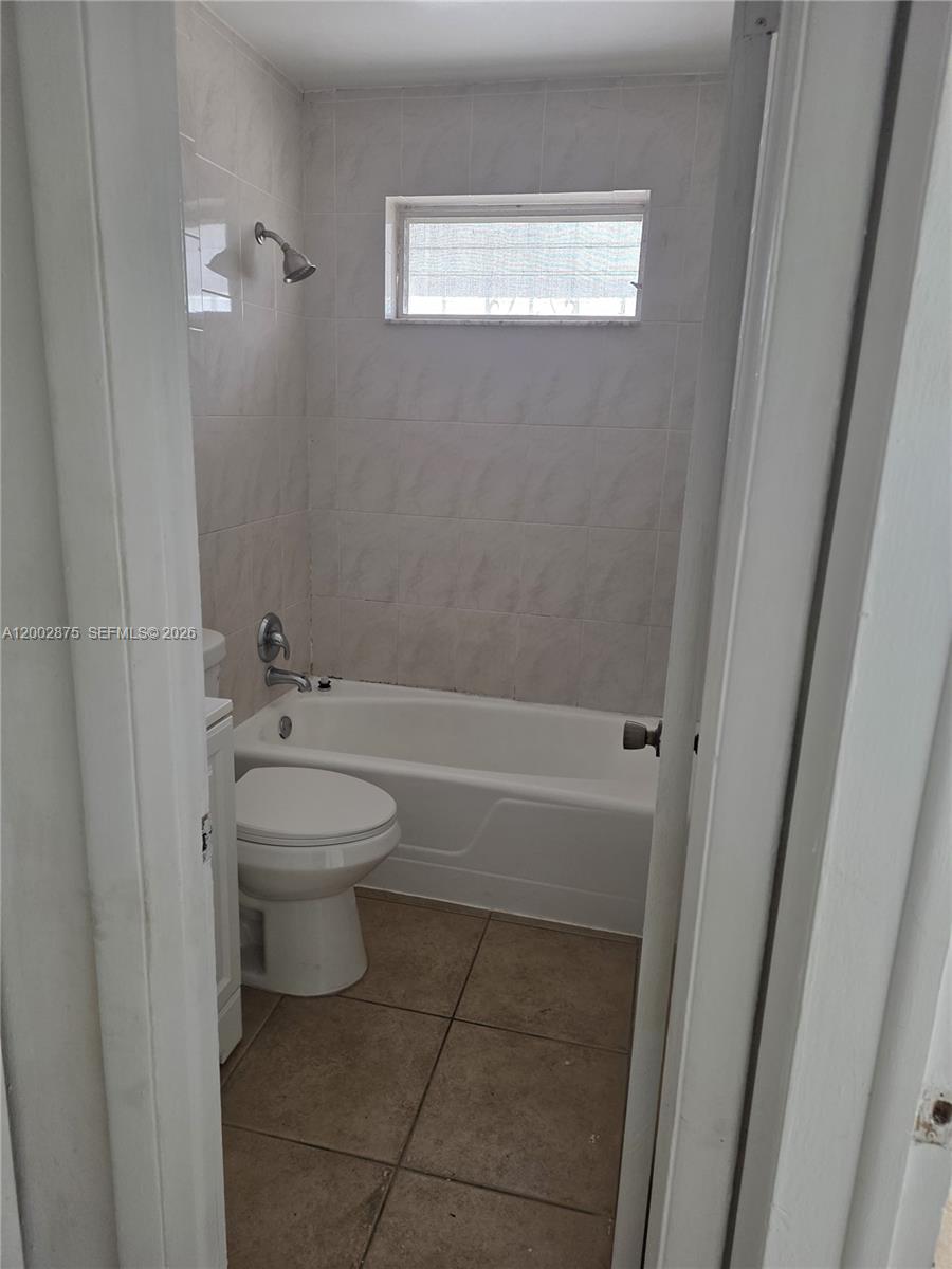 412 Southwest 10th Street, Unit 12 Hallandale Beach, FL 33009 - Photo 10 of 11 a bathroom with a toilet sink and shower