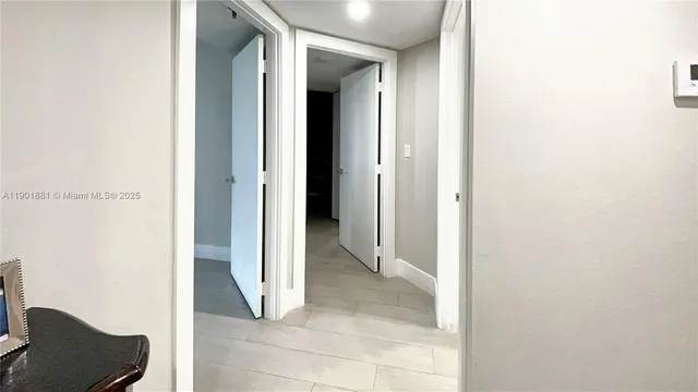 a view of a hallway with bathroom and shower