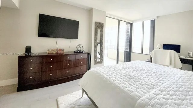 a bedroom with a bed and a flat screen tv