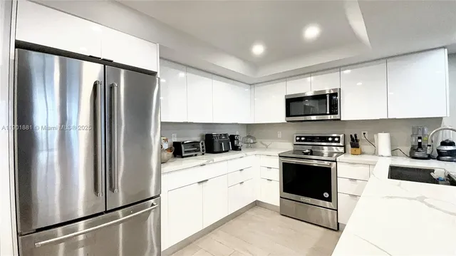 a kitchen with stainless steel appliances a refrigerator stove microwave and sink
