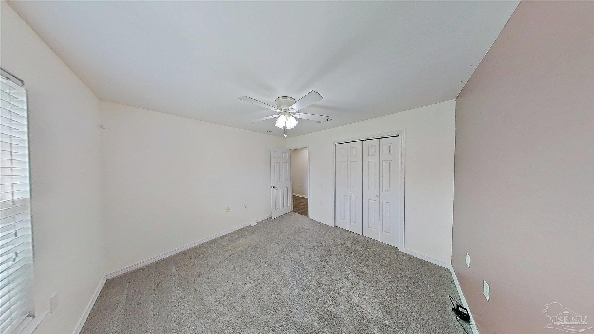 1039 Brownfield Road Pensacola, FL 32526 - Photo 13 of 14 an empty room with closet and a chandelier fan