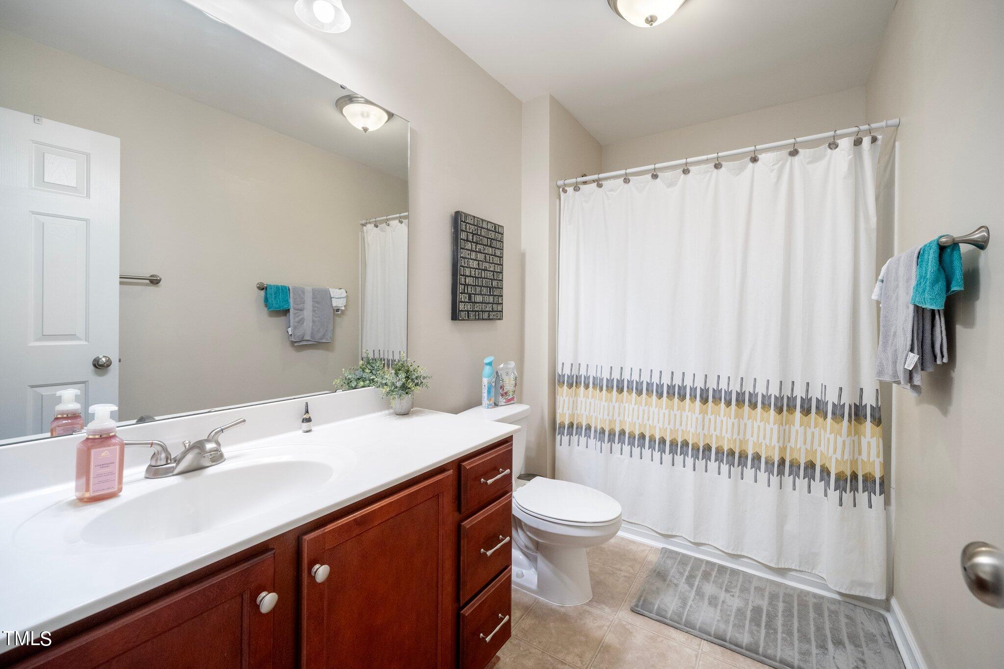 903 Ambergate Station Apex, NC 27502 - Photo 17 of 24 a bathroom with a double vanity sink toilet and shower