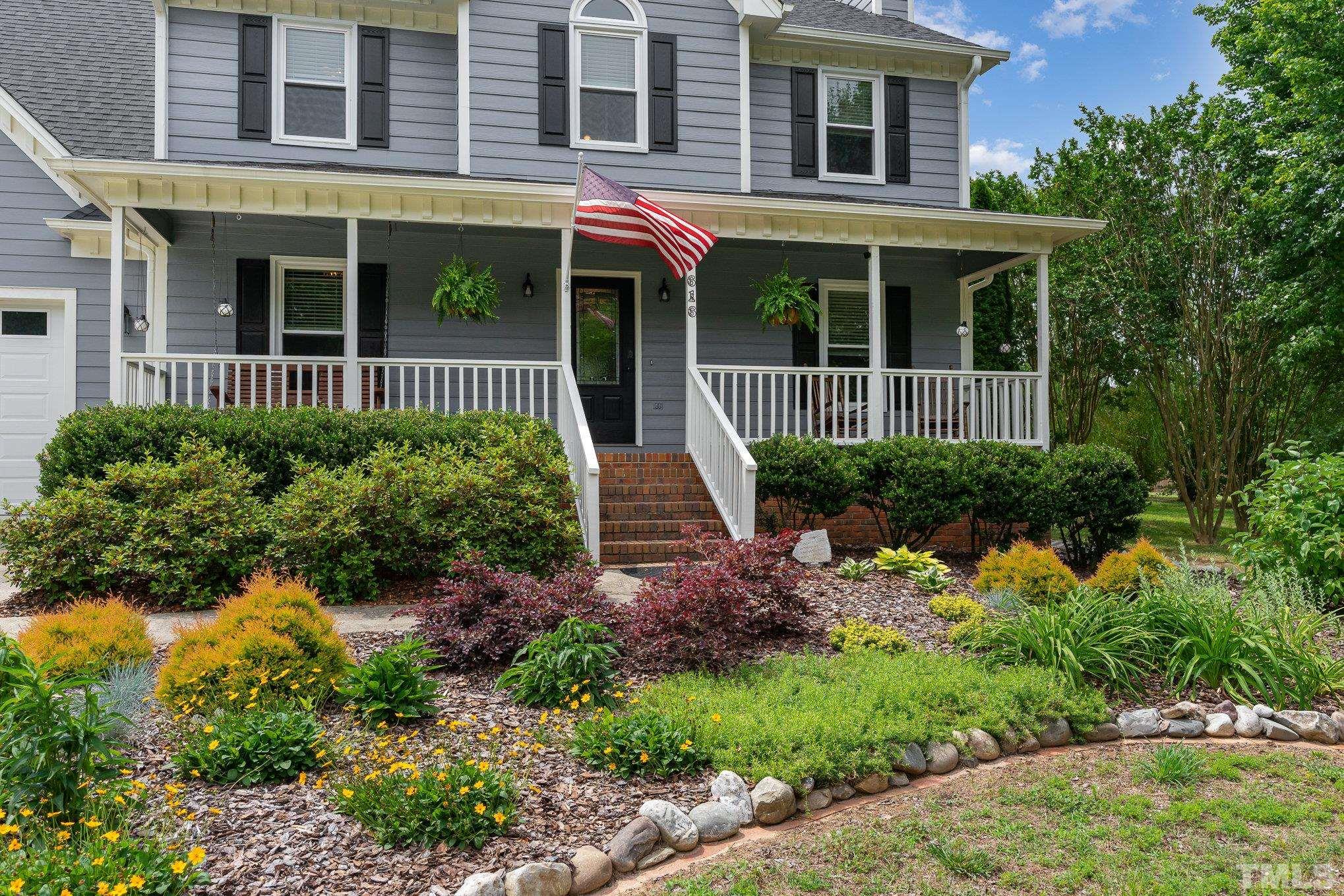 616 Jordan Ridge Lane Raleigh, NC 27603 - Photo 3 of 31 a view of a brick house with a flower garden