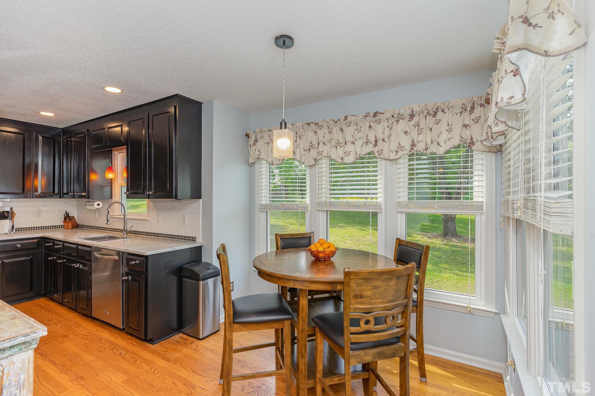 616 Jordan Ridge Lane Raleigh, NC 27603 - Photo 5 of 31 a kitchen with a table chairs sink and cabinets