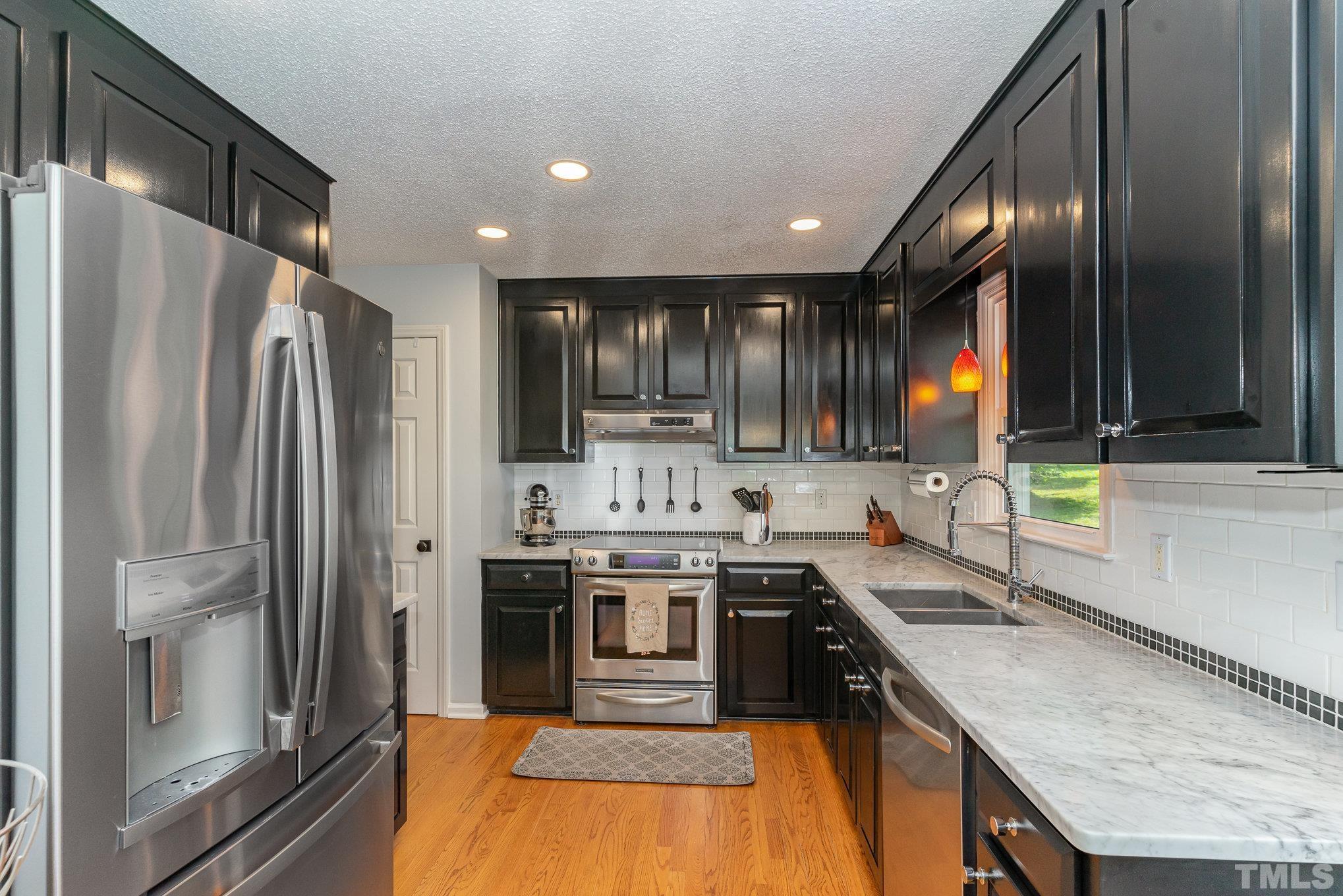 616 Jordan Ridge Lane Raleigh, NC 27603 - Photo 6 of 31 a kitchen with stainless steel appliances granite countertop a sink a stove and a refrigerator