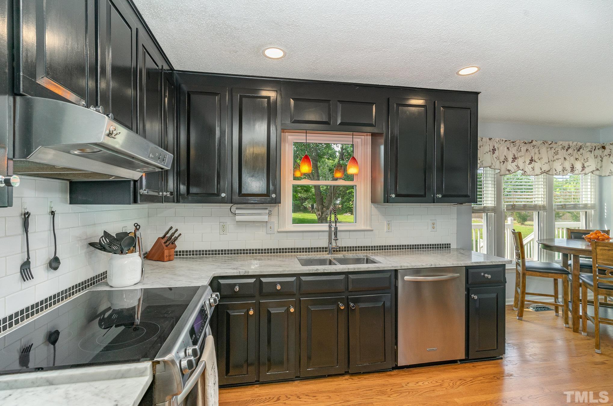 616 Jordan Ridge Lane Raleigh, NC 27603 - Photo 7 of 31 a kitchen with stainless steel appliances granite countertop a sink stove and cabinets
