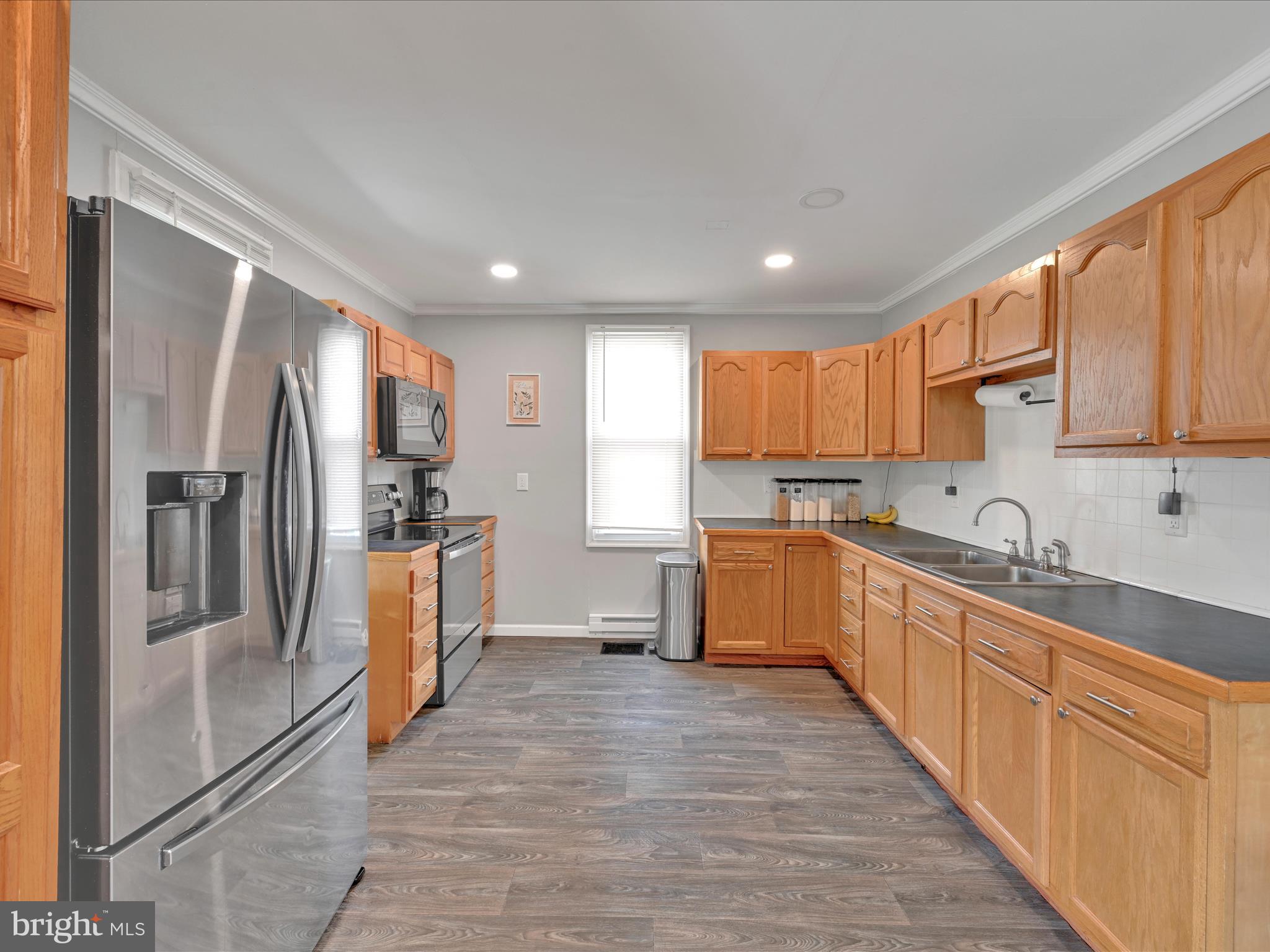 1056 Bellaire Road Elizabethtown, PA 17022 - Photo 11 of 30 a large kitchen with stainless steel appliances granite countertop a refrigerator a sink dishwasher a stove with wooden cabinets and floor