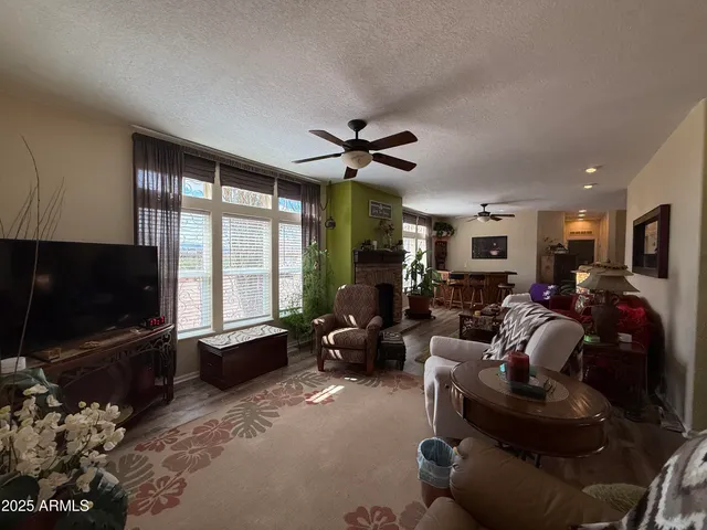 a living room with furniture a flat screen tv and a large window