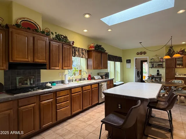 a kitchen with stainless steel appliances granite countertop a stove a sink dishwasher and cabinets with wooden floor