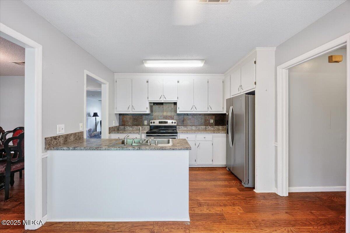 117 Chadwick Drive Macon, GA 31210 - Photo 18 of 32 a kitchen with a refrigerator a sink and dishwasher with wooden floor
