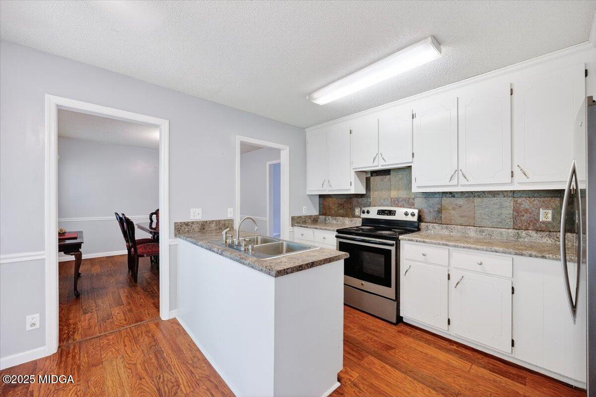 117 Chadwick Drive Macon, GA 31210 - Photo 19 of 32 a kitchen with stainless steel appliances kitchen island granite countertop a stove a sink and white cabinets