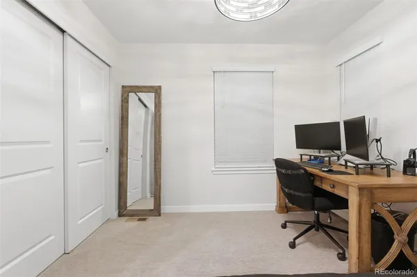a view of a workspace with furniture and a window
