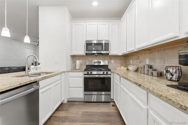 a kitchen with granite countertop a sink and a stove