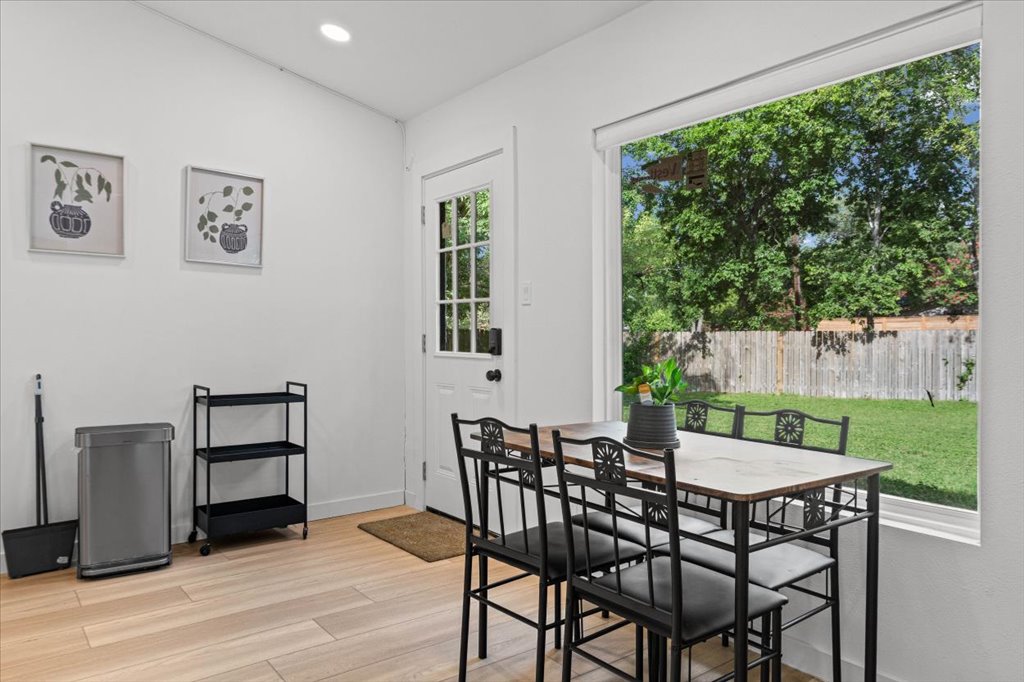 1406 North Georgetown Street Round Rock, TX 78664 - Photo 5 of 34 The eating area offers views of a verdant yard through a generously sized window, complementing the light wood flooring.