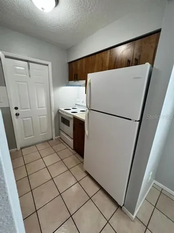 a kitchen with a refrigerator sink and cabinets