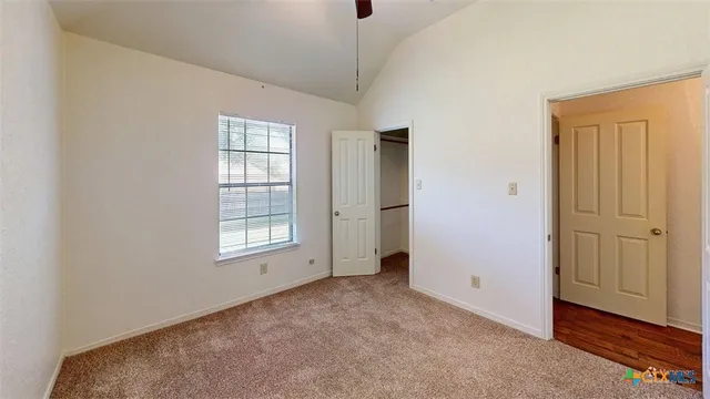 a view of a big room with wooden floor and windows