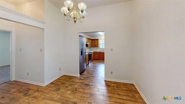 a view of a room with wooden floor and chandelier