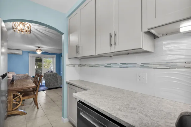 a kitchen with stainless steel appliances granite countertop a sink and a white cabinets with wooden floor