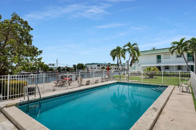 a view of a house with a swimming pool and sitting area
