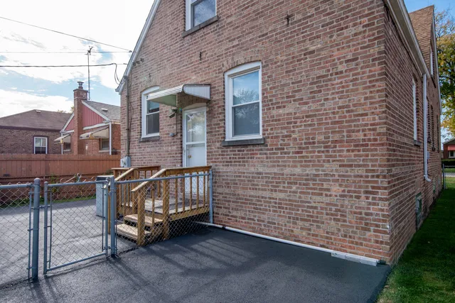 a view of a brick house with chairs in front of it