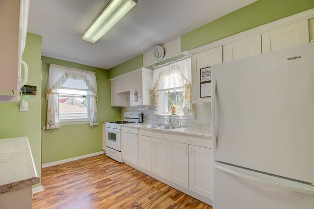 a kitchen with a sink window and cabinets
