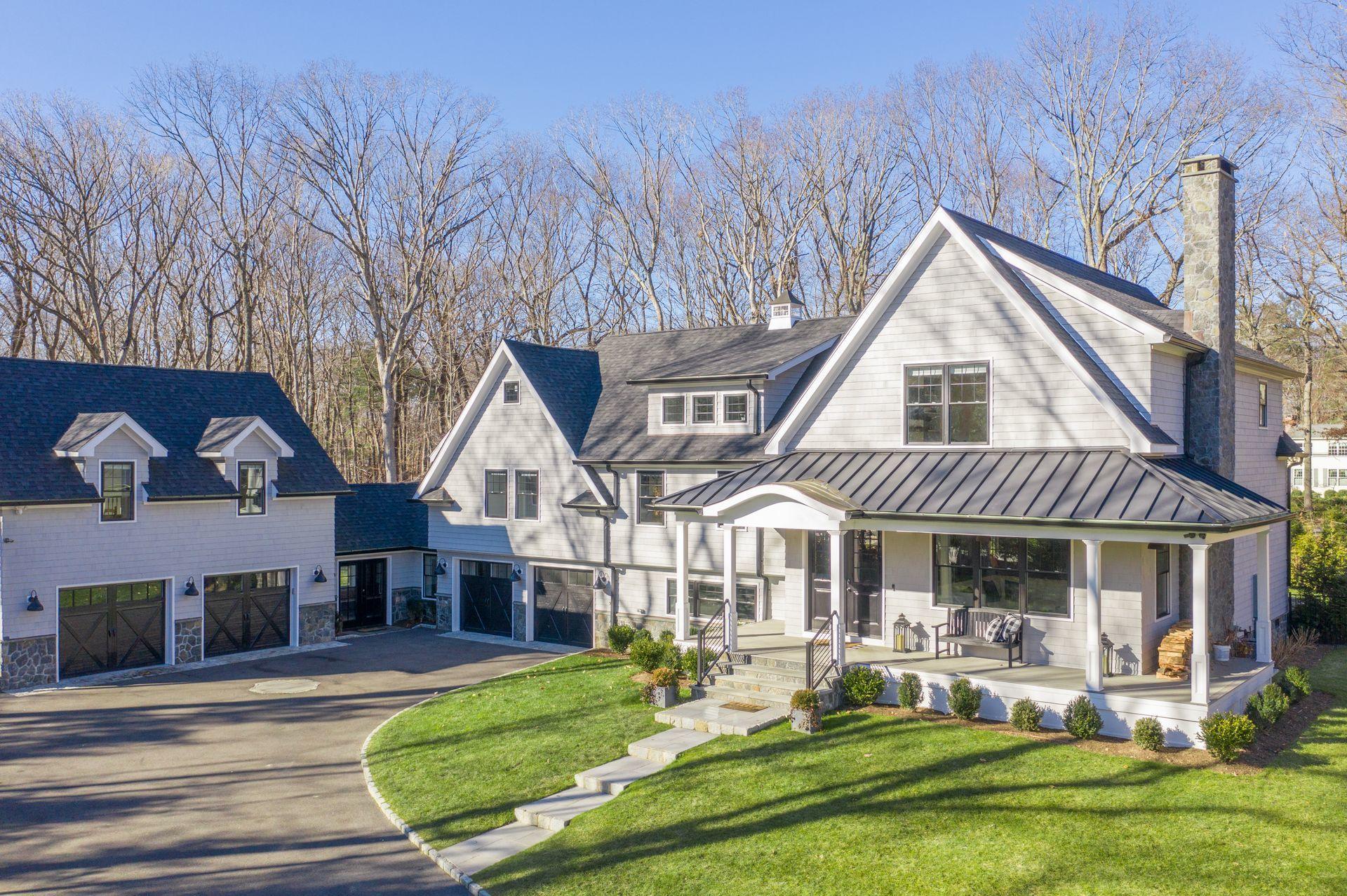 716 Cheese Spring Road New Canaan, CT 06840 - Photo 52 of 56 a front view of a house with a yard table and chairs