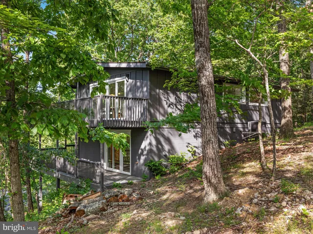 a view of a house with a yard and large trees