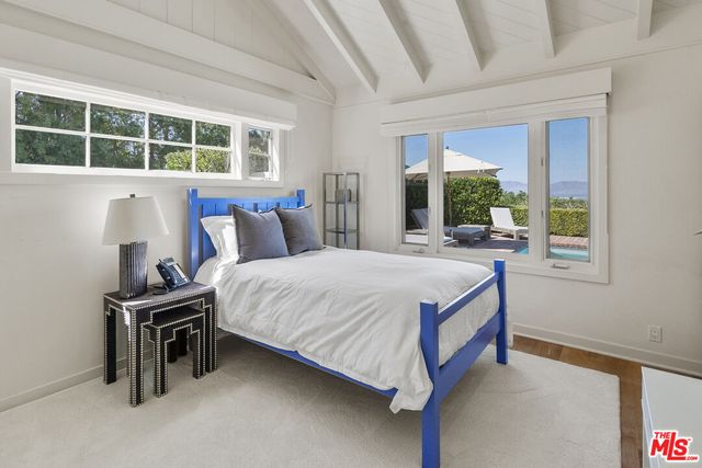 a bed room with furniture and a mirror