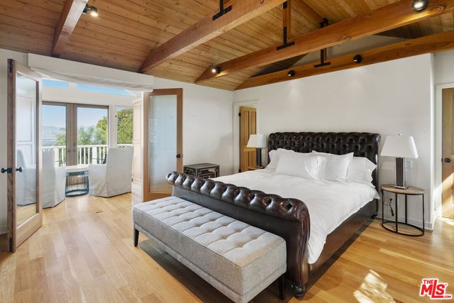 a large bed sitting in a bedroom next to a window