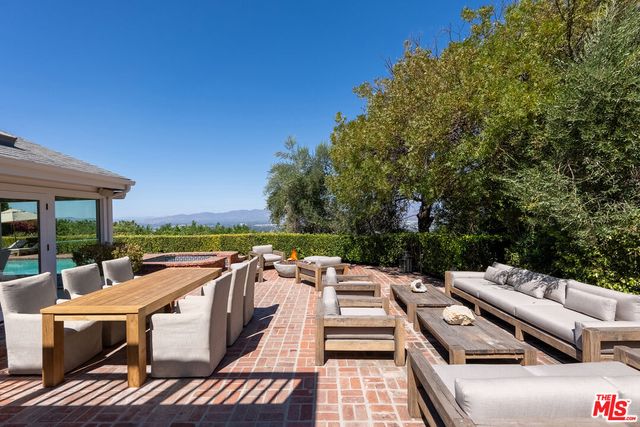 a view of a patio with couches table and chairs and potted plants