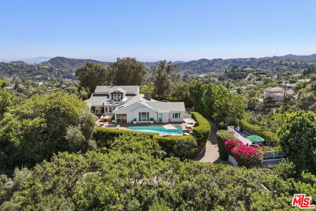 an aerial view of a house with swimming pool and patio