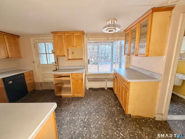 a living room with furniture and a refrigerator