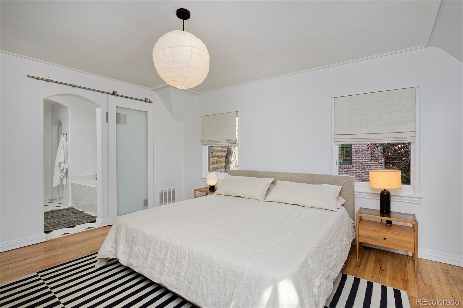 590 Race Street Denver, CO 80206 - Photo 27 of 50 a bedroom with a bed and a chandelier